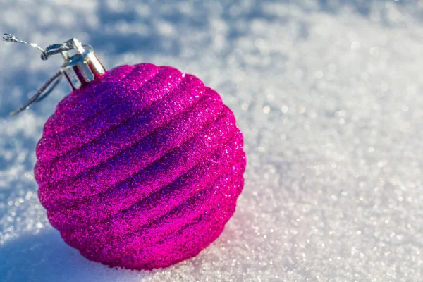 Pink new year ball lie on a snow — Stock Photo, Image