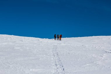 Beyaz kış tepeler arasında yürüyüşçü