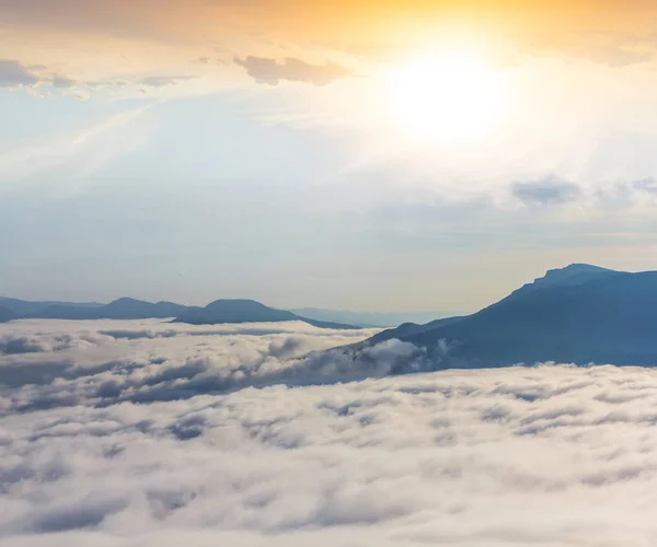 Encosta da montanha em nuvens ao pôr do sol — Fotografia de Stock