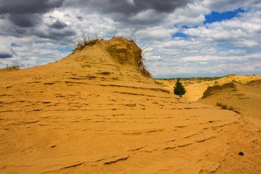 yoğun bulutlu gökyüzü ve sıcak kumlu çöl