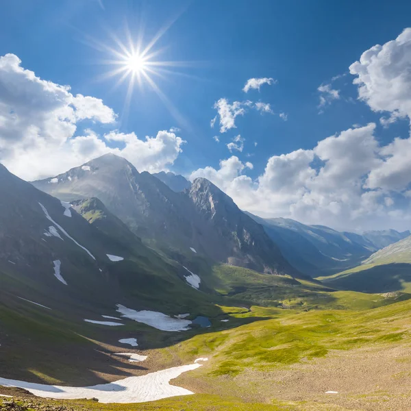 Soleggiata valle di montagna verde sotto un sole scintillante — Foto Stock