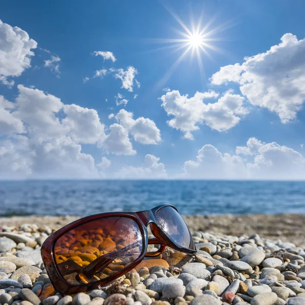 Sole riflesso in occhiali su una costa di mare — Foto Stock