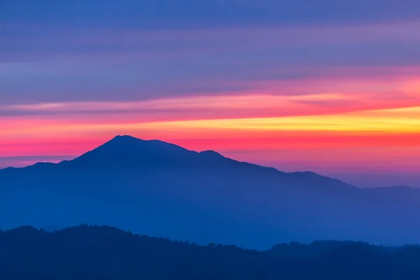 Silueta de cresta de montaña sobre un fondo de cielo temprano en la mañana — Foto de Stock