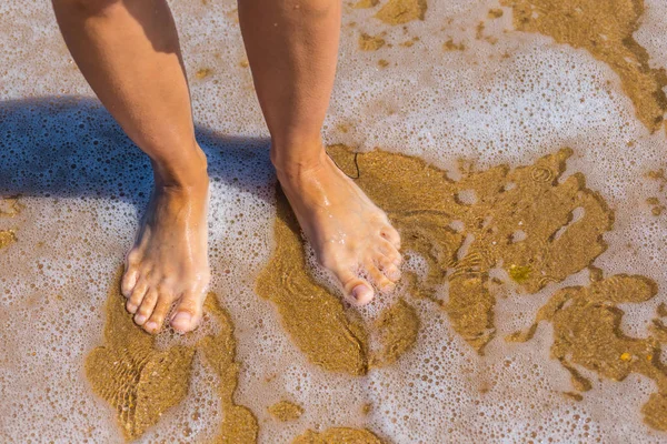 Primer plano piernas de mujer en una playa de mar —  Fotos de Stock