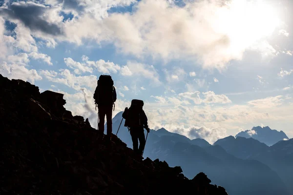 Silueta de excursionistas en una ladera de montaña —  Fotos de Stock