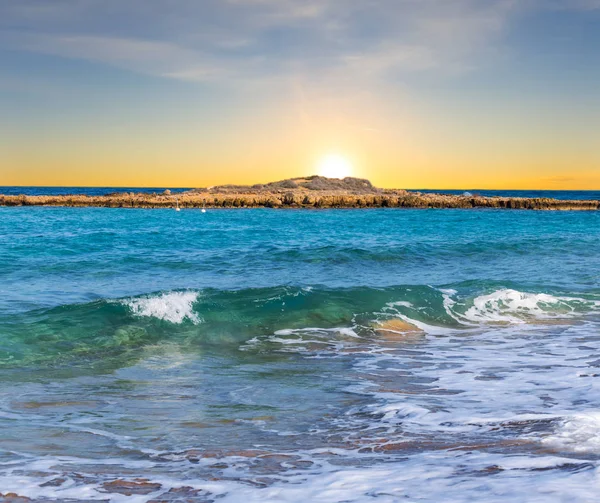Puesta de sol sobre una pequeña bahía del mar mediterráneo — Foto de Stock