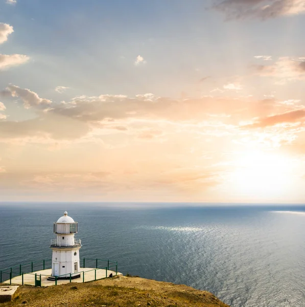 在日落时的海洋披风上的灯塔 — 图库照片