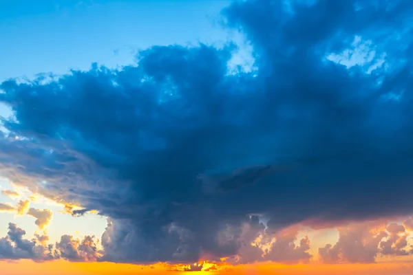 Dramatiska solnedgången bakgrund med täta enorma moln — Stockfoto
