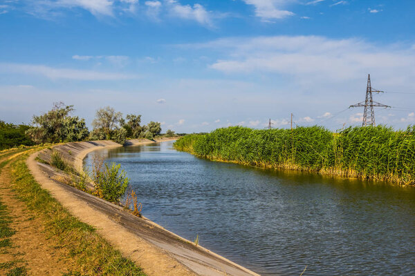 разворот оросительного канала, голубое небо, лето
