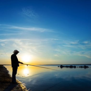 Fisher siluet günbatımı bir arka plan üzerinde