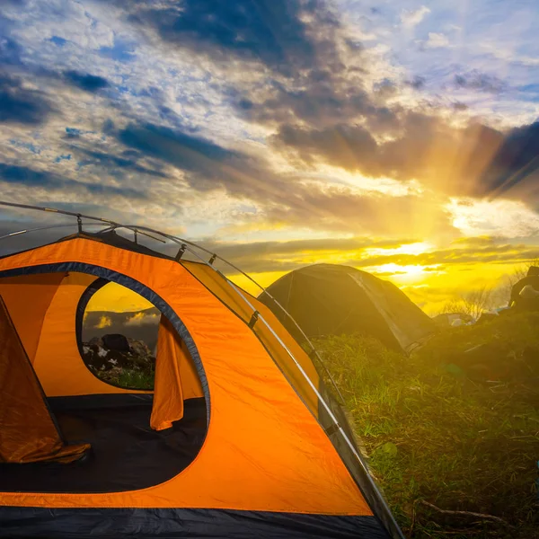 bir gün batımı arka planda turuncu turistik çadır