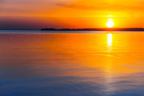 Dramatischer Sonnenuntergang, der sich in einem Wasser spiegelt — Stockfoto