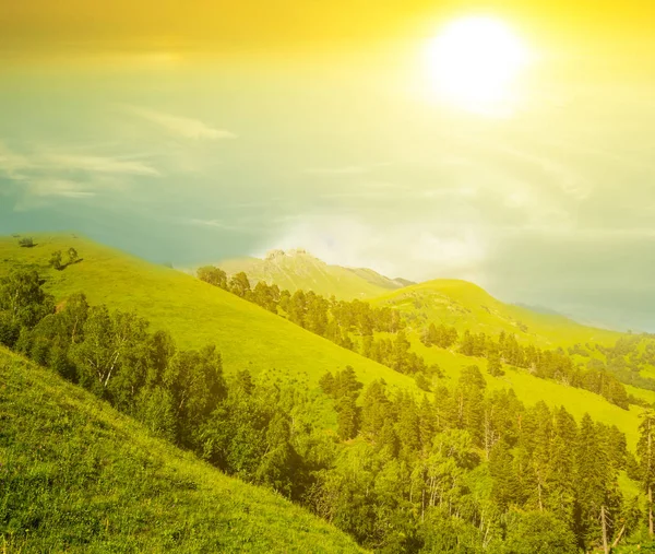 Pôr-do-sol silencioso sobre uma encosta de montagem verde — Fotografia de Stock