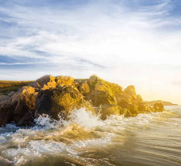 岩石的海岸和日落时的波 — 图库照片