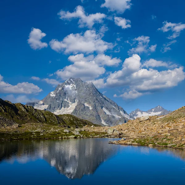 Puncak gunung psush tercermin dalam danau gunung yang tenang — Stok Foto