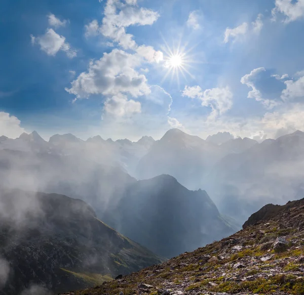 Montanha pico nevoeiro céu e brilho sol — Fotografia de Stock