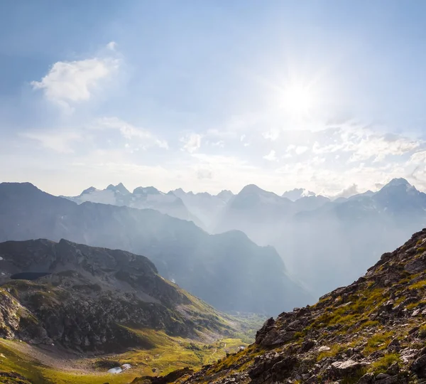 Vallée de montagne dans une brume sous un soleil étincelant — Photo