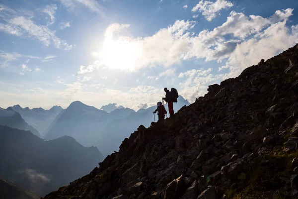 Silueta de excursionistas en una ladera de montaña — Foto de Stock