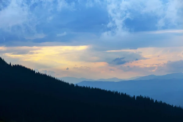 Yamaç siluet bir akşam gökyüzü arka plan üzerine monte — Stok fotoğraf