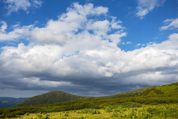 yeşil dağların mavi bir bulutlu gökyüzü altında