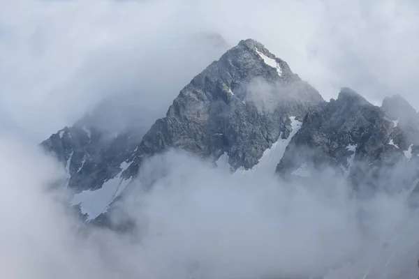 Alto pico de montagem em nuvens densas — Fotografia de Stock