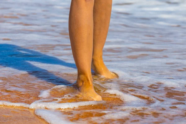 Primer plano piernas de mujer en una playa de mar —  Fotos de Stock