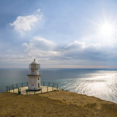 güneşli bir gün, bir deniz kıyısındaki beyaz deniz feneri