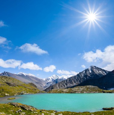 bir ışıltı güneş altında bir dağ sırtı arasında güzel zümrüt göl
