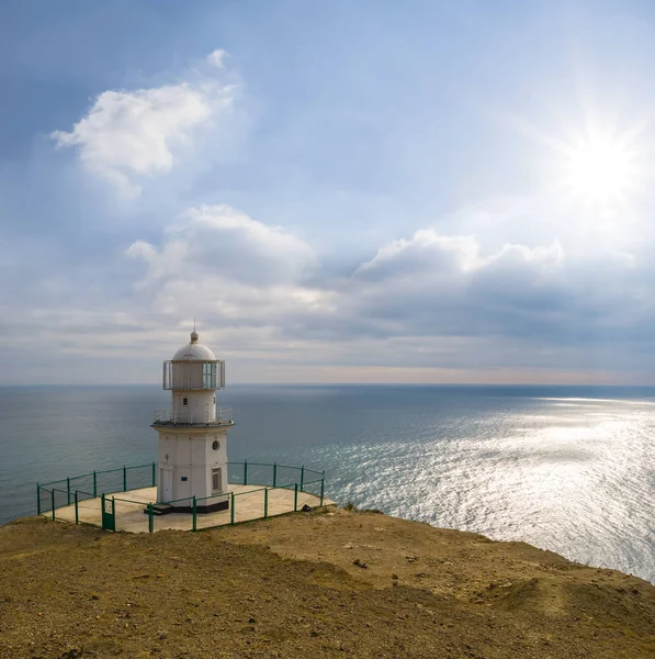 Phare blanc sur une côte de la mer au soleil jour — Photo