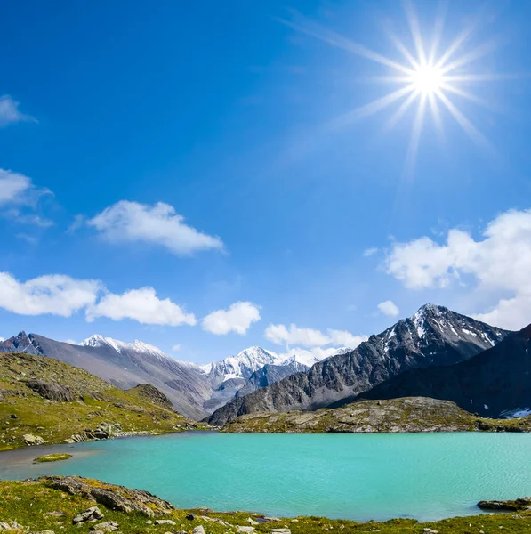 Hermoso lago esmeralda entre una cresta de montaña bajo un sol brillante —  Fotos de Stock