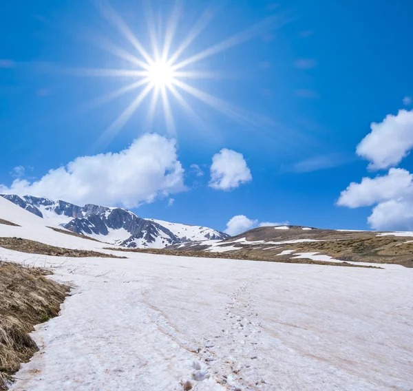 Montañas nevadas de primavera bajo un sol brillante —  Fotos de Stock