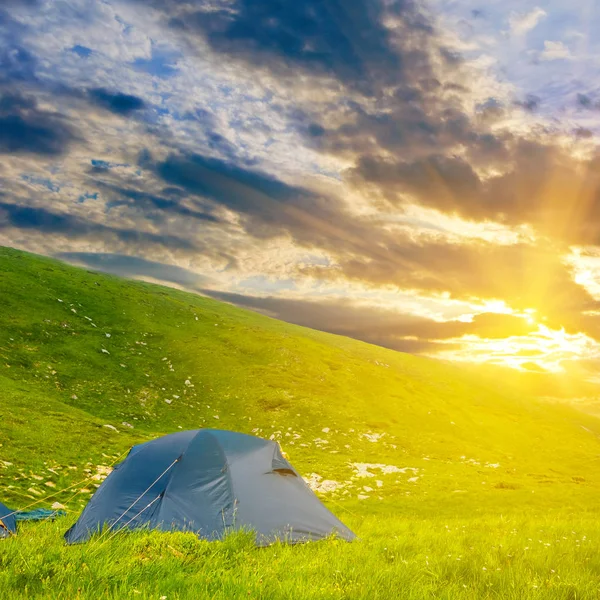 Acampamento turístico entre umas colinas ao pôr do sol — Fotografia de Stock