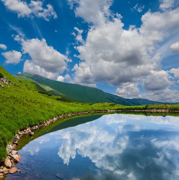 Kaunis sininen järvi vihreässä vuoristolaaksossa — kuvapankkivalokuva