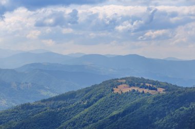 Yeşil dağ sırtı bir bulutlu gökyüzü altında