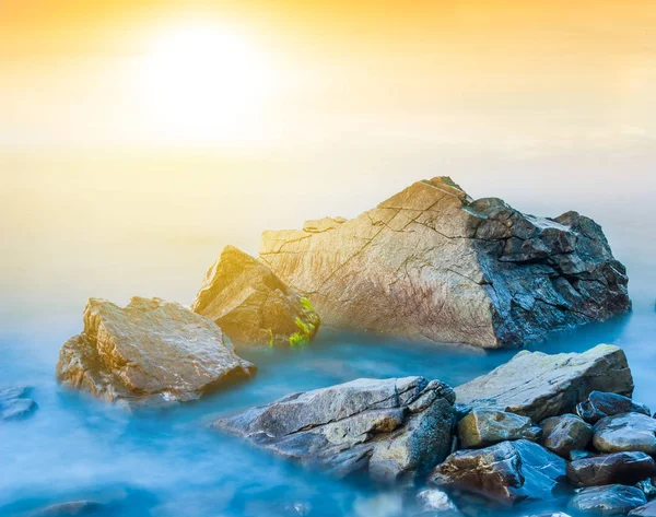 Крупним планом камені в морі на заході сонця — стокове фото