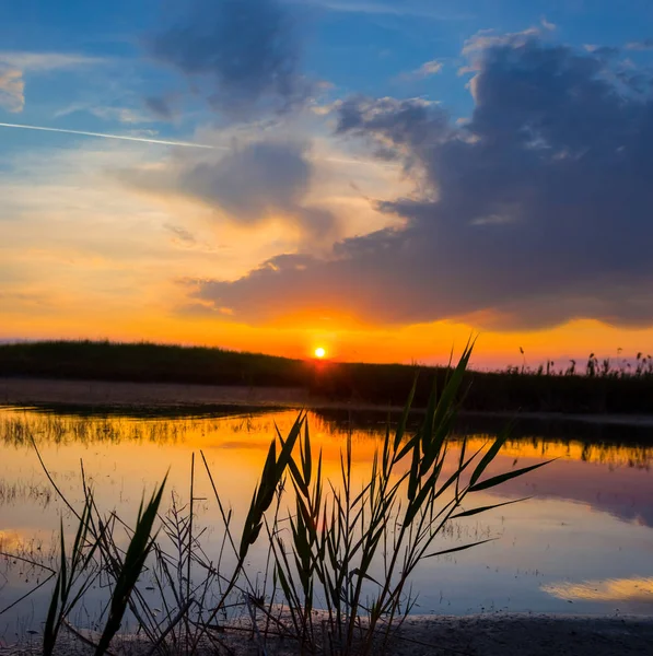 Pôr do sol dramático sobre um lago tranquilo — Fotografia de Stock