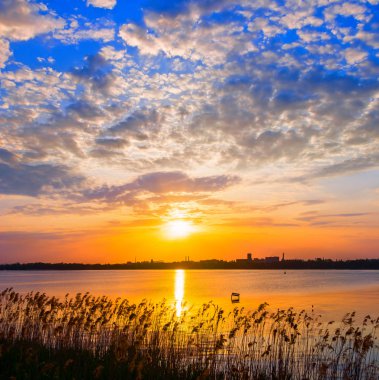 büyük bir göl üzerinde dramatik günbatımı