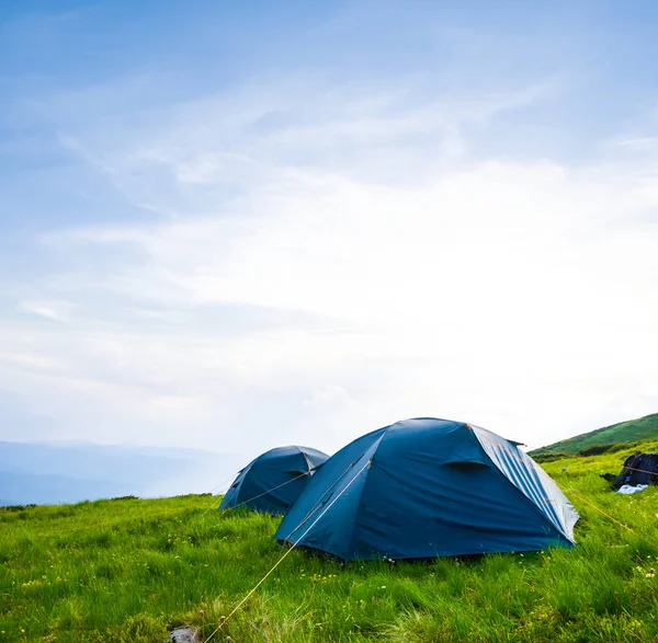 Campement touristique sur une pente verdoyante — Photo