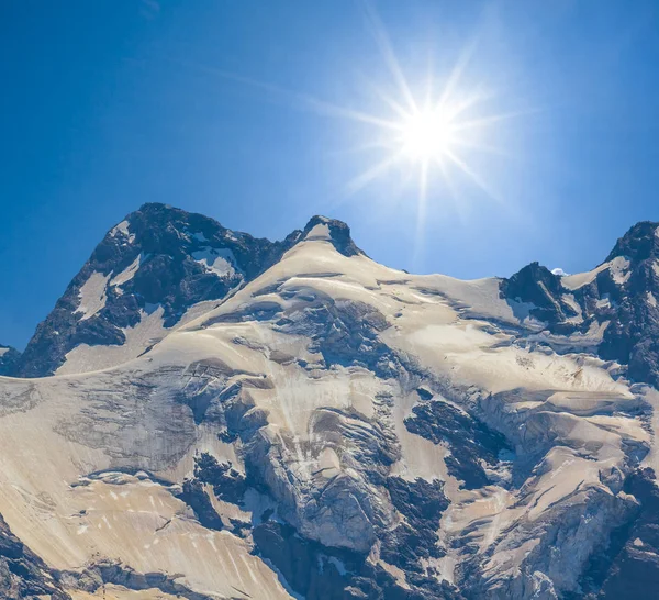 在闪耀的阳光下 在雪中登上山顶 — 图库照片