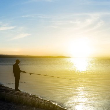Fisher siluet günbatımında bir Nehri üzerinde