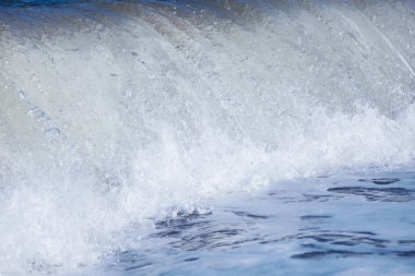 Kapalı deniz vajinası sahile vuruyor, yaz tatili arka planında.