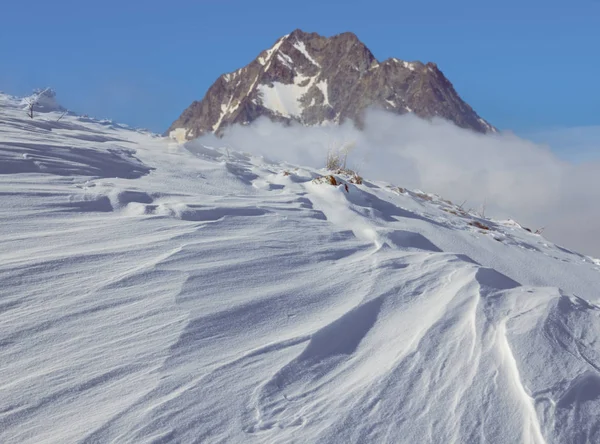 冬の山の風景雪の山の斜面雲の岩の上 — ストック写真