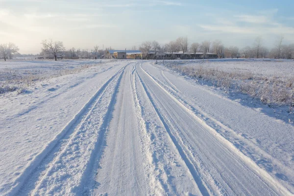 在冬季平原间的近景雪地路 — 图库照片