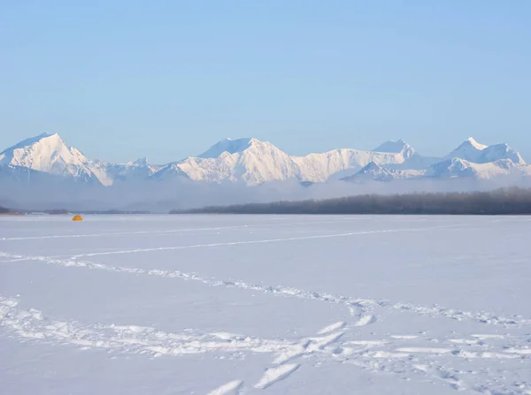 winter snowbound plain before a mountain chain, winter outdoor natural background