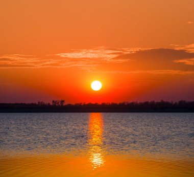 Deniz Körfezi üzerinde kırmızı dramatik günbatımı
