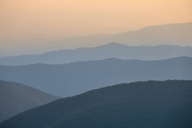 Dağ sırtı silueti Alacakaranlıkta mavi bir sis içinde