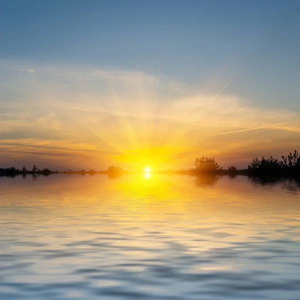 湖の上の劇的な夕日夜の太陽は水に反射し — ストック写真