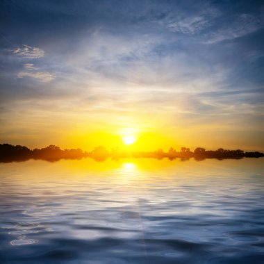 Sakin bir göle yansıyan dramatik gün batımı, akşam arkaplanı.