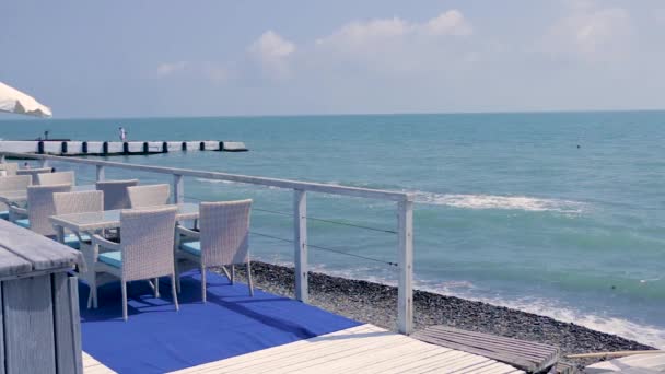 Table avec chaises contre le bord de la mer . — Video