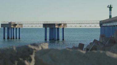 Deniz iskelesi kayalık kıyısında bulanık: ön ile yavaş Panoraması.
